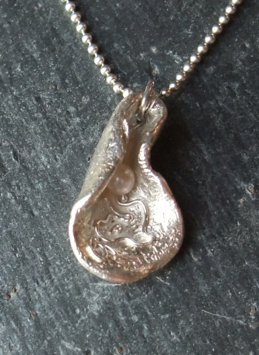 'Hidden Pearl' handmade silver pendant inspired by the sea: tiny pearl caught in the folds of a shel