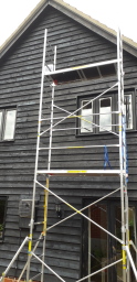 Exterior painting of a barn with scaffold tower