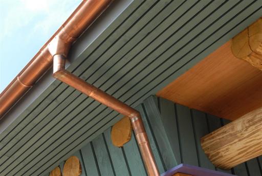 Newly installed half round copper guttering and round downpipe