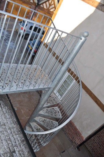 Spiral Steel Staircase with ornate Scroll pattern treads.