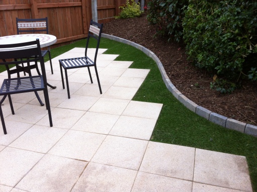 Small back patio space created and complimented with artificial grass