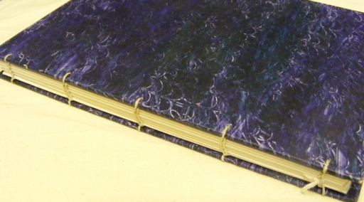 A Handbound Book, sewn with Coptic Binding and paste painted covers by artist Ros Williams