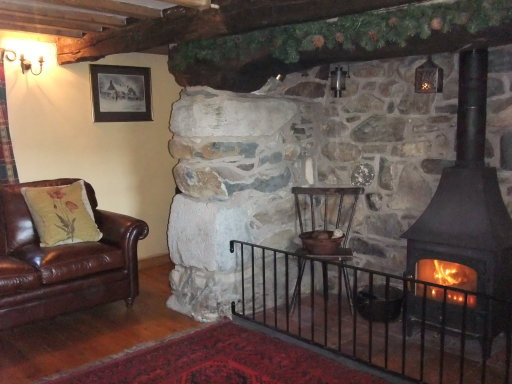 sitting room with wood burning stove and leather sofas