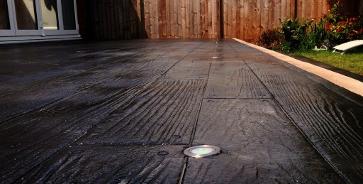 Slate black imprinted concrete decking with neon blue led recessed lighting