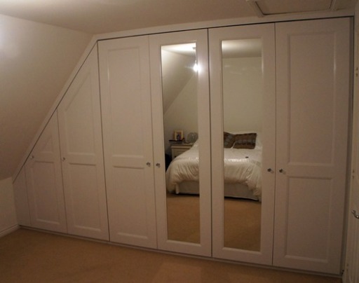 Panel and beaded painted fitted wrdrobe doors into alcove.