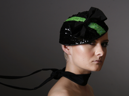 Black and green sequinned hat with patent leather bow