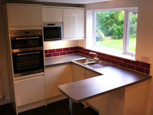 Kitchen renovation in Saughall. High gloss cream units with a breakfast bar