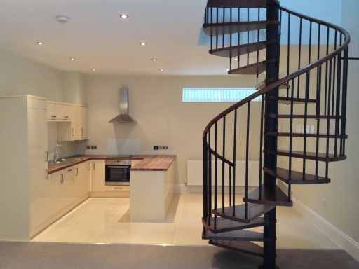 spiral stair for coach house in harrogate in black finish with chestnut coloured beech stair treads