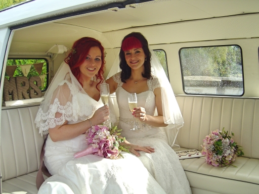 Two beautiful Brides enjoying champagne in Jodi VW split screen campervan Silk and Satin Weddings