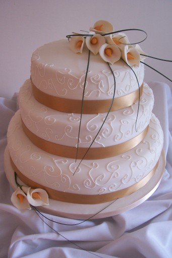 3 tier ivory wedding cake with gold lillies