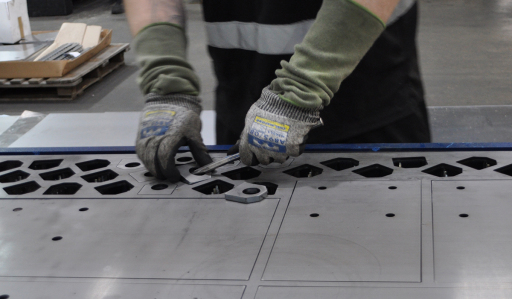Laser cut components being separated from a sheet