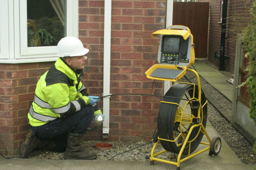 Flexible camera inserted into a gully drain to locate a cracked pipe