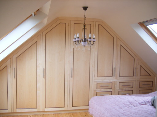 Handmade contemporary angled wardrobe made from sycamore with the walnut beading.