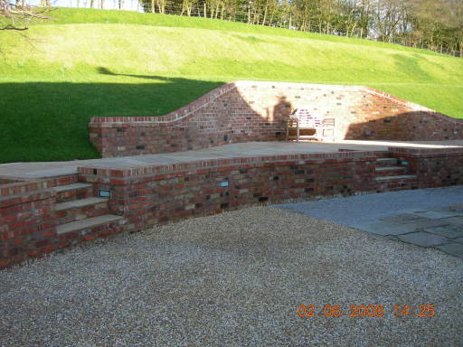 landscaping with reclaimed cheshire brick wall and indian stone patio