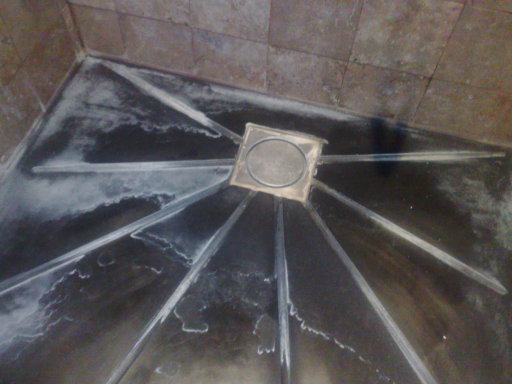 Built up hard water scale to base of shower