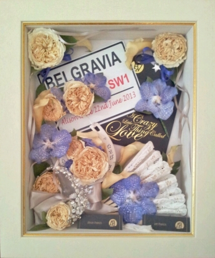 A keepsake frame, full of flowers &amp; memorabilia from a 1920s themed wedding