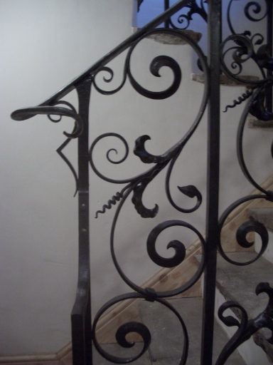 Hand forged hand rail with scrollwork and water leaf infill.