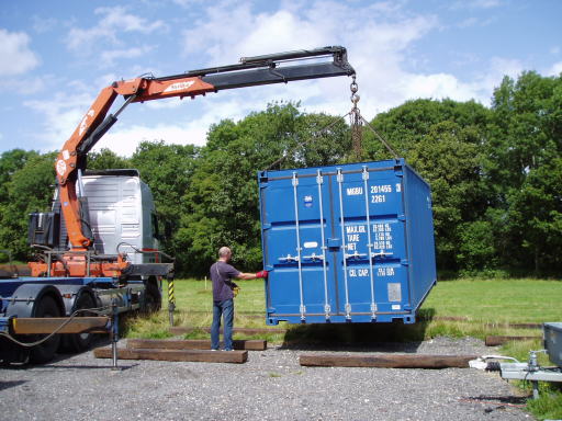 20ft new one trip container being unloaed by crane mounted vehicle