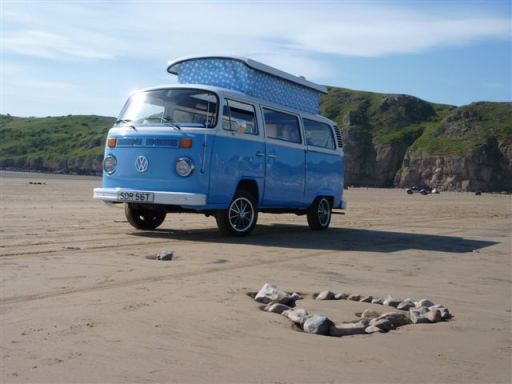 blue devon vw camper van on beach