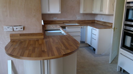 Walnut effect laminate worktops and up-stands finished square edged.