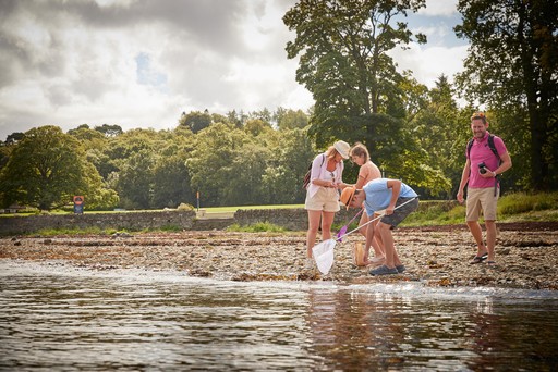 Family look for wildlife along the banks of the Holy Loch at Hunters Quay Holiday Village