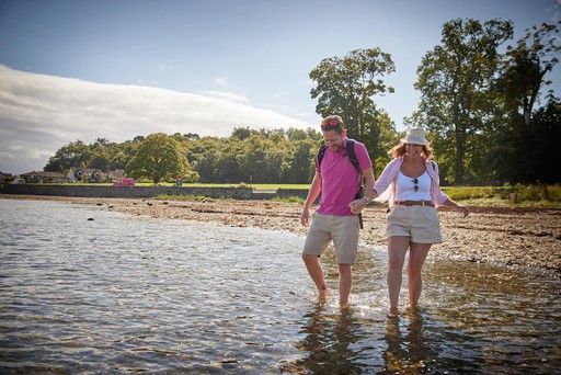 Couple dip their feet in the Holy Loch at Hunters Quay Holiday Village
