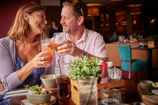 Couple enjoy drinks in Hunters Bar and Grill at Hunters Quay Holiday Village
