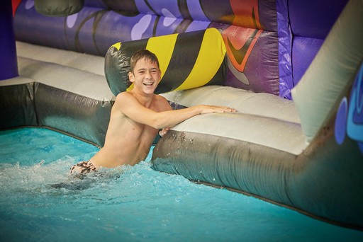 Kid climbing back onto the Go Aqua Run inflatable at Hunters Quay Holiday Village