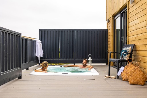 Couple relax in the Hot Tub of their Luxury Eco Lodge at Gwel an Mor