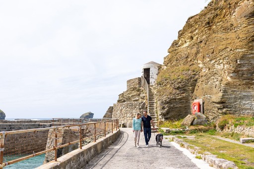 Couple walk with their dog along Portreath Beach, a short walk from Gwel an Mor