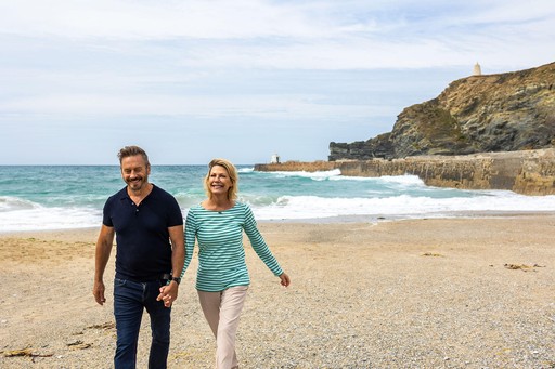 Couple walk along Portreath Beach, a short walk from Gwel an Mor