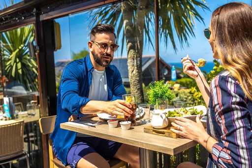 Couple enjoy food and drinks from The Terrace Bar & Restaurant at Gwel an Mor