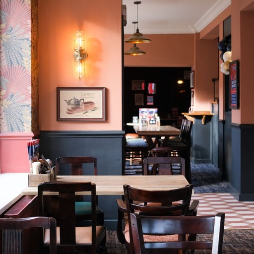 Inviting dining space with warm lighting, wooden tables and soft tones, ideal for relaxed meals with friends or family.
