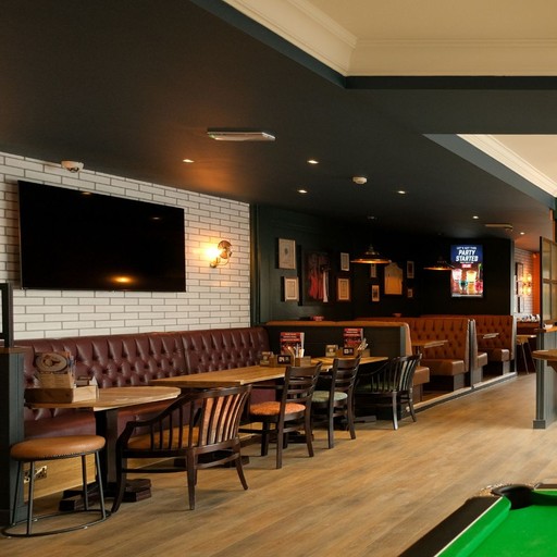 Spacious booth seating area with wall-mounted screens, perfect for group dining and watching live sport.