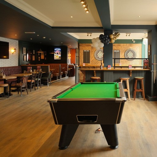 Large open-plan space featuring a central pool table, bar seating and social areas for games, drinks and gatherings.