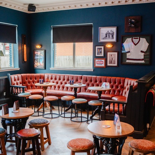 Comfortable booth seating area with framed sports memorabilia, offering a relaxed space for drinks and casual dining.