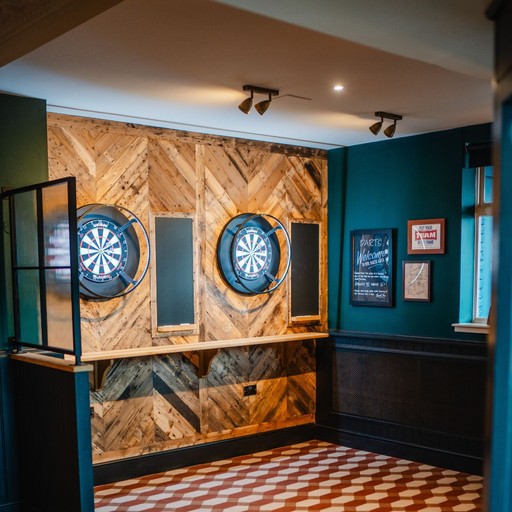 Dedicated darts area with modern boards and stylish wooden panelling, great for friendly competition.