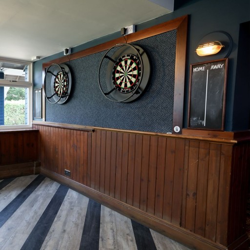 Dedicated darts area with dual boards and a central scoreboard, perfect for friendly competition and social games.