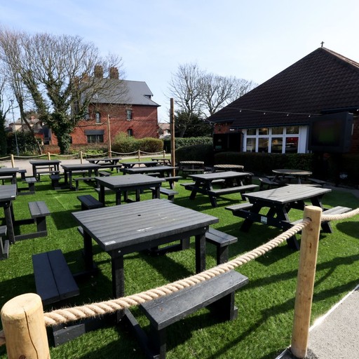 Spacious outdoor seating area with picnic benches, providing plenty of space for drinks and socialising.
