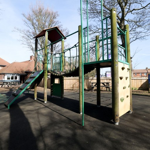 Outdoor play area with climbing frame and slide, offering a family-friendly space for younger guests.