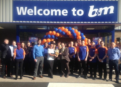Radio Metro's Cash for Kids charity pose with staff as they receive £250 worth of B&M vouchers, as a thank you for taking part in the opening ceremony.