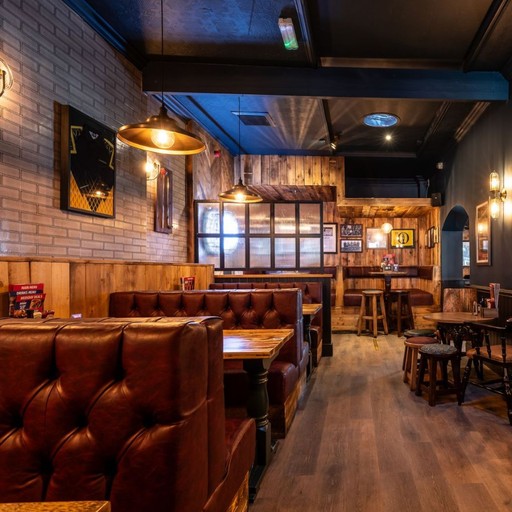 Warm and stylish dining area with booth seating, wooden finishes and ambient lighting, perfect for relaxed meals and drinks.