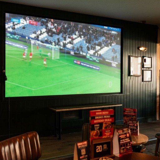 Dedicated sports viewing space with a large screen and comfortable seating, perfect for watching live matches.