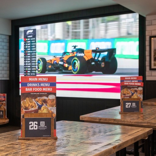Open-plan bar area with tables, stools and large screens, perfect for drinks, dining and watching live sport.