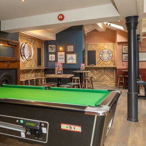 Large open-plan space featuring a central pool table, bar seating and social areas for games, drinks and gatherings.
