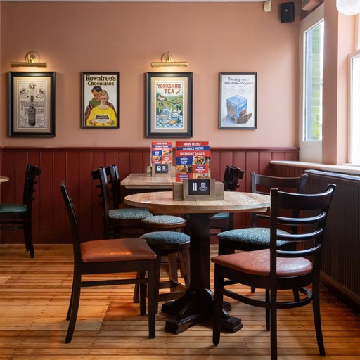 Cosy table by a large window, offering a bright and comfortable setting for casual drinks or dining.