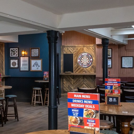 Dedicated darts setup with scoreboard and nearby bar seating, ideal for casual games and drinks.