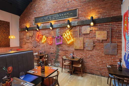 Warm Zizzi Winchester interior with vibrant décor and neon signs on wall.