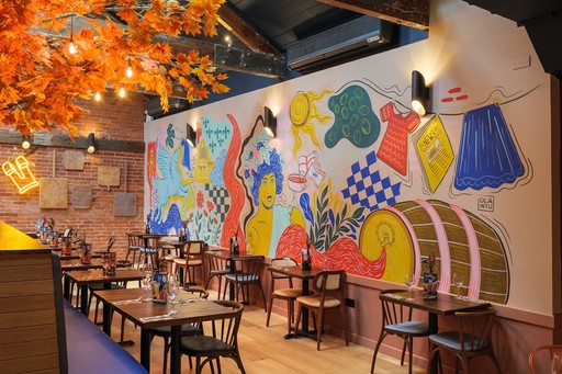 Warm Zizzi Winchester interior with vibrant décor, art murals and neon signs on wall.