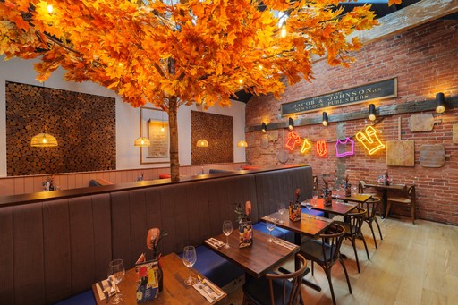 Warm Zizzi Winchester interior with vibrant décor, art murals and neon signs on wall.